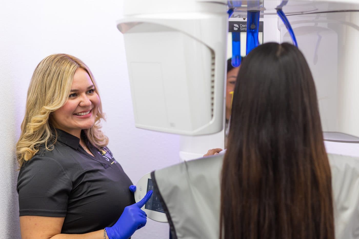 A Soleil Dental Mesquite team member smiling as she positions a patient for an x-ray