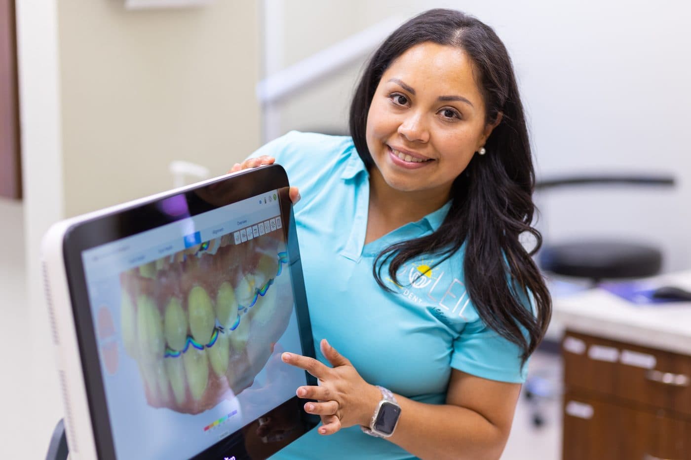 Dr. Diana Vazquez holding up a screen with a 3D scan of a patient's teeth
