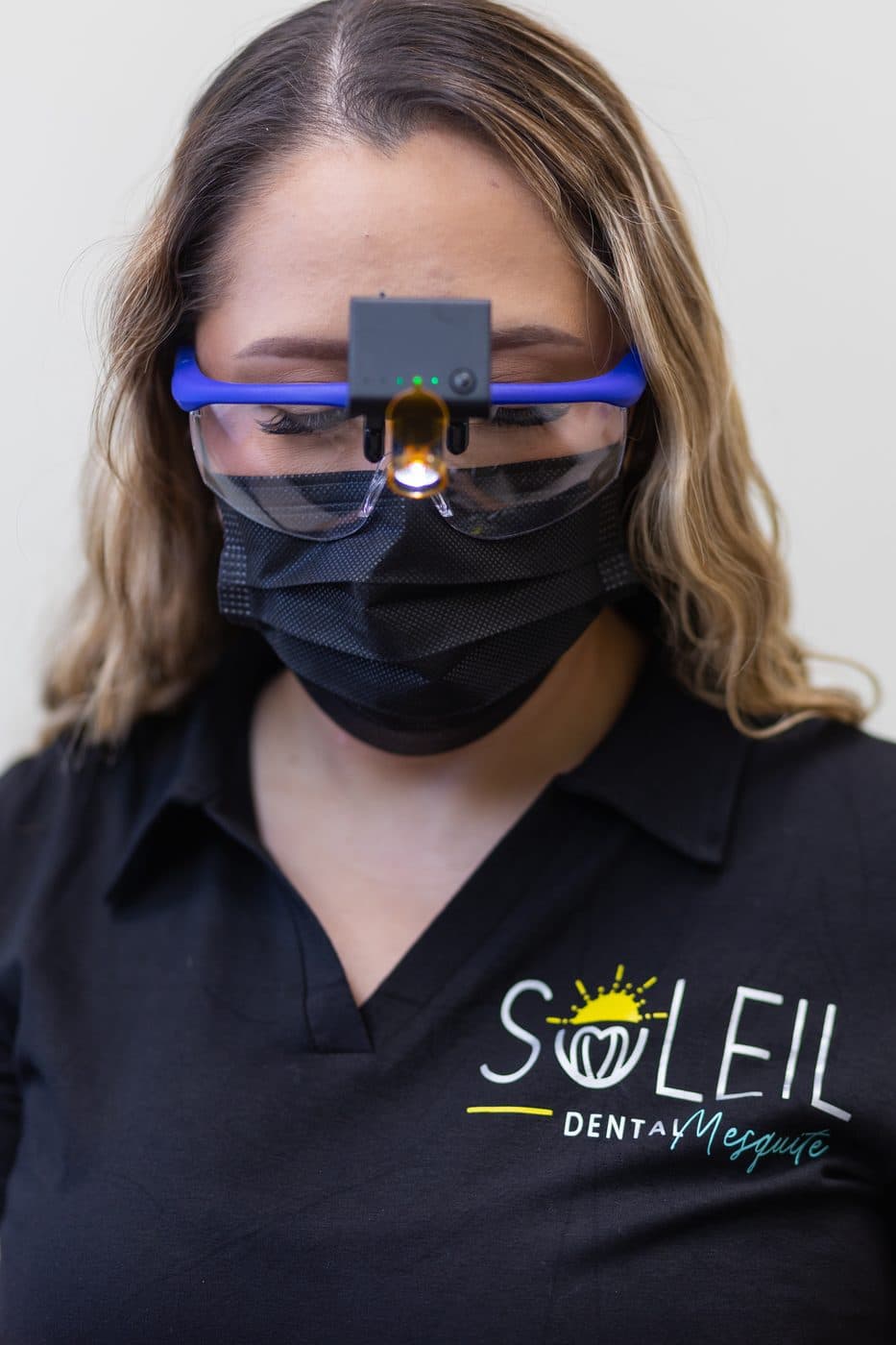 A Soleil Dental Mesquite team member wearing magnifying loupes with a light